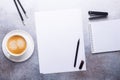 Office workplace with blank paper, cup of coffee, note pad and pen. Stone background. Top view Royalty Free Stock Photo
