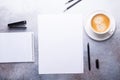 Office workplace with blank paper, cup of coffee, note pad and pen. Stone background. Top view Royalty Free Stock Photo