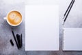 Office workplace with blank paper, cup of coffee, note pad and pen. Stone background. Top view Royalty Free Stock Photo