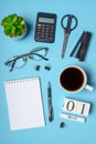 Office workplace with coffee cup, eyeglasses, calculator, stationery and plant. Date 01 March on wooden block calendar. White Royalty Free Stock Photo