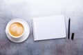 Office workplace with cup of coffee, note pad and pen. Stone background. Top view Royalty Free Stock Photo