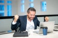 Office workplace. Excited business man working with laptop at desk in office. Businessman typing on keyboard, online Royalty Free Stock Photo