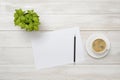 Office workplace with green houseplant, cup of coffee, white paper and pencil in top view Royalty Free Stock Photo