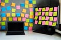 Office workplace with laptop and desktop pc full of blank colorful sticky notes reminders. Royalty Free Stock Photo