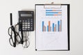 Office workplace, top view. analytics chart, calculator and glasses lie on a white table