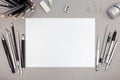 Office workspace with blank paper sheet and various drawing tool