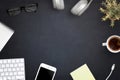 Office workspace with computer keyboard, smart phone, cup of coffee, headphones, glasses, notepad, plant