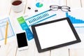 Office workspace displaying tablet, smartphone, documents, and coffee cup during work hours Royalty Free Stock Photo