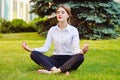 Office yoga. Business lady in lotus pose sits on green grass. Re Royalty Free Stock Photo