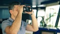 Officer during navigational watch looking through binoculars