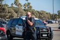 An officer from Ventura City Police Department puts on a mask as he arrives at a search of a vehicle.