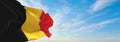 official flag of Belgium civil , Belgium at cloudy sky background on sunset, panoramic view. Belgian travel and patriot concept.