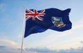 official flag of Falkland Islands at cloudy sky background on sunset, panoramic view. patriot and travel concept. copy space for