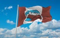 official flag of Grise Fiord, Nunavut Canada at cloudy sky background on sunset, panoramic view. Canadian travel and patriot