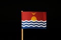 A official Flag of Kiribati on wooden stick on black background. State in the middle Oceania, pacific ocean. Royalty Free Stock Photo