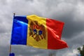 The official flag of the state of the Republic of Moldova against the sky