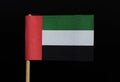 A official flag of the united arab Emirates on toothpick on black background. A horizontal tricolour of green, white and black