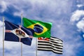 Official flags of the country Brazil, state of Sao Paulo and city of Guarulhos. Swaying in the wind under the blue sky. 3d