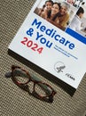 Closeup, 2024 Medicare and You Handbook for Medicare Recipients With a Pair of Glasses