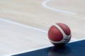 An official orange ball on a hardwood basketball court Royalty Free Stock Photo