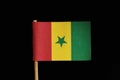 A official and original flag of Senegal on toothpick on black background. A vertical tricolour of green yellow and red with green