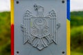 Official plate with the coat of arms of the state of the Republic of Moldova on a customs or border post. Background