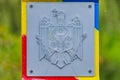 Official plate with the coat of arms of the state of the Republic of Moldova on a customs or border post. Background