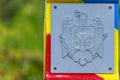 Official plate with the coat of arms of the state of the Republic of Moldova on a customs or border post. Background