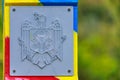 Official plate with the coat of arms of the state of the Republic of Moldova on a customs or border post. Background