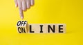 Offline and online symbol. Businessman hand points at turned wooden cubes with words Online and Offline. Beautiful yellow