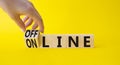 Offline and online symbol. Businessman hand turnes wooden cubes and changes word Online to Offline. Beautiful yellow background.
