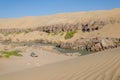 Offroad camping at Kunene River in front of towering ancient Namib Desert sand dunes of Namibia and Angola Royalty Free Stock Photo