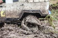 Offroad car stuck in deep mud with flat tyre. Royalty Free Stock Photo