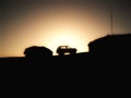 Car between shacks in the mountains at sunset