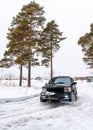 Offroad SUV `Jeep Grand Cherokee` 4x4 with off- road training rides in winter on snow in the forest among pines with a female.