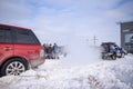 Offroad SUV `Range Rover 4x4` pulls the rope with a jeep `Suzuki Escudo` in winter in the snow in the Parking lot