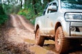 Offroad travel and driving concept, Wheel closeup in a countryside landscape with a muddy road, Off-road travel on muddy road Royalty Free Stock Photo