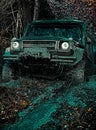 Offroad vehicle coming out of a mud hole hazard. 4x4 travel trekking. Drag racing car burns rubber. Extreme. Tires in Royalty Free Stock Photo