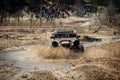 Offroad vehicle makes splashes of dirty water at sunny day