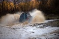 Offroading. Scene of wather splash in off-road racing. A car during a tough off-road competition diving in a muddy pool Royalty Free Stock Photo