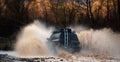 Offroading. Scene of wather splash in off-road racing. A car during a tough off-road competition diving in a muddy pool Royalty Free Stock Photo