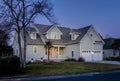 Offset view of beautiful luxury home at dusk with lights Royalty Free Stock Photo