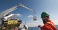 Offshore crane lifting operations - men attending tag lines