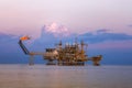 Offshore oil and rig platform in sunset or sunrise time. Construction of production process in the sea Royalty Free Stock Photo