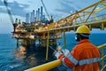 Offshore Oil Rig Worker Inspects Complex Platform Structure at Dusk, Utilizing Advanced Technology for Efficient Operation and
