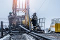 Offshore oil rig worker prepare tool and equipment for perforation oil and gas well at wellhead platform. Making up a drill pipe