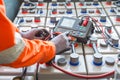 An offshore oil rig worker used meter to measuring voltage of batteries at oil and gas platform