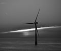 Offshore turbine and sun behind the clouds at dawn