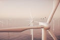 Offshore wind farm turbines caught in sunset sky. Beautiful contrast with the blue sea. ecological concept. 3d rendering Royalty Free Stock Photo