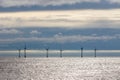 Offshore wind farm turbines on sea horizon with cloudscape background